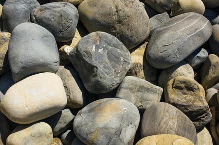 boulders and colorful pebbles on the beach on a warm summer day