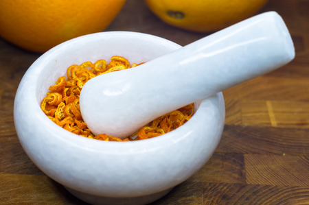White marble mortar and pestle with the dried orange zestの写真素材