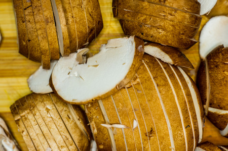 sliced before cooking fresh king mushrooms champignons on a bamboo Board close-upの写真素材