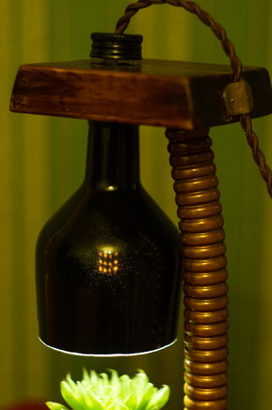 Light fixture handmade - stand for flower pot in vintage style, wooden case, copper fittings, led lamp on a black background.の写真素材