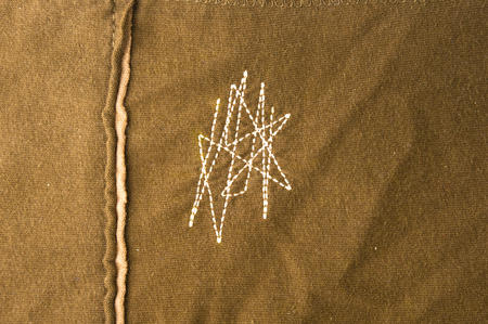 texture of the fabric is khaki with decorative seams and stitching, close-upの写真素材