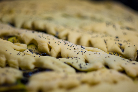 raw homemade rustic pie with apples, poppy seeds and jam, close-upの写真素材