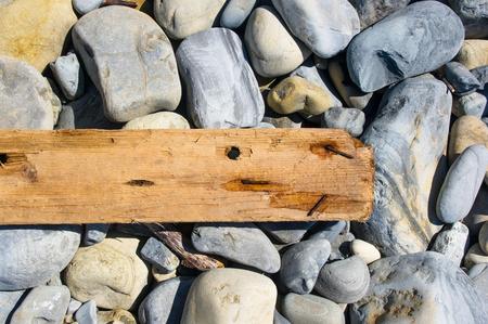 driftwood, washed up by the sea on a pebble beach on a warm summer dayの写真素材