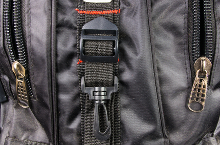 closeup of buckles, clasps, zippers, pockets, fasteners, fittings and seams in the black backpackの写真素材
