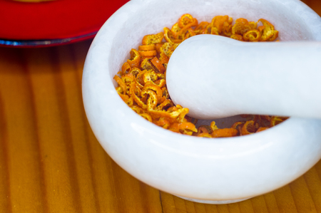 White marble mortar and pestle with the dried orange zestの写真素材