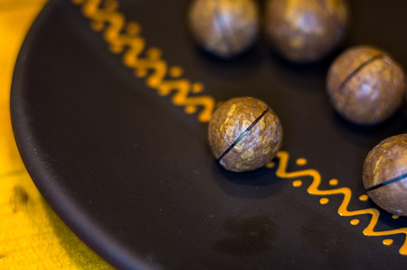 macadamia, Australian nut in a ceramic plate on a wooden table, close-upの写真素材