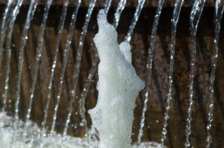 Fountain in city park on hot summer day, beautiful bright streams of sparkling water, drops and splashes.の写真素材