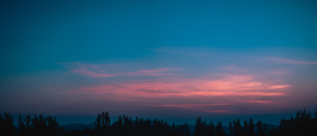 Landscape with dramatic light - beautiful golden sunset with saturated sky and clouds, peaceful nature serene background.の写真素材