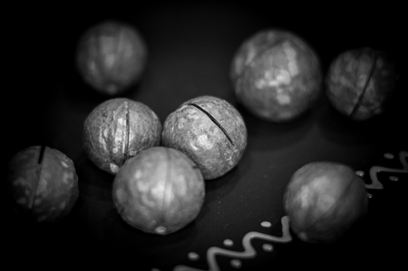 macadamia, Australian nut in a ceramic plate on a wooden table, close-up, tonedの写真素材
