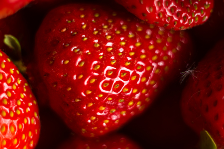 fresh ripe berries strawberries on black ceramic plate on white background, macro photo