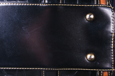 closeup of buckles, clasps, zippers, pockets, fasteners, fittings and seams on black leather hand bagの写真素材