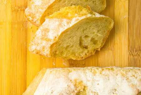 fresh sliced loaf of white wheat bread on wooden background