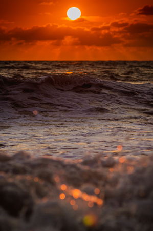 Summer sea sunset, the sun, waves and clouds, beautiful dramatic lightingの写真素材