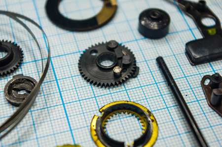 parts are completely disassembled old retro film SLR camera on graph paper, close-up