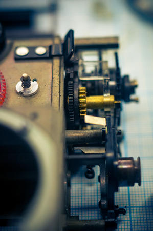 parts are completely disassembled old retro film SLR camera on graph paper, close-up, tonedの写真素材