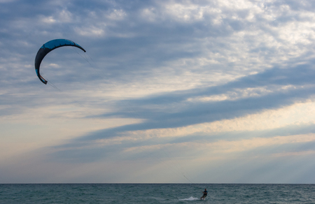 kitesurfer rides a kite-surf on waves of the sea in a small storm on a summer dayの写真素材