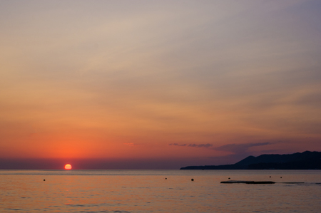 Summer sea sunset, the sun, waves and clouds, beautiful dramatic lightingの写真素材