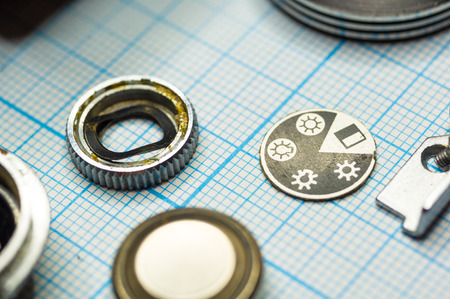 parts are completely disassembled old retro film SLR camera on graph paper, close-up