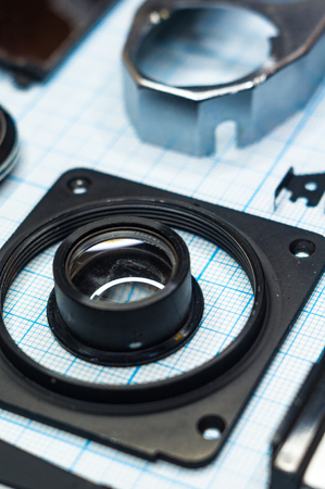 parts are completely disassembled old retro film SLR camera on graph paper, close-upの写真素材