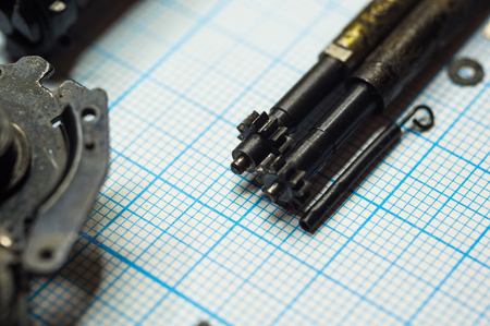 parts are completely disassembled old retro film SLR camera on graph paper, close-upの写真素材