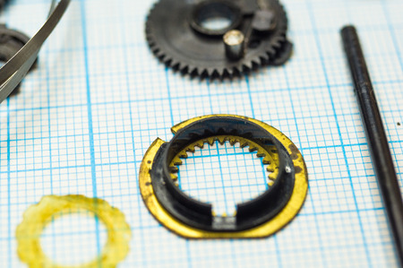 parts are completely disassembled old retro film SLR camera on graph paper, close-up