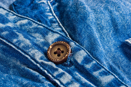 Blue washed faded jeans texture with seams, clasps, buttons and rivets, clothing items, macro, close-upの写真素材
