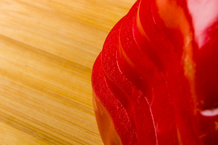 stacked pile of sliced fresh red paprika, bell pepper on bamboo cutting Board, close upの写真素材