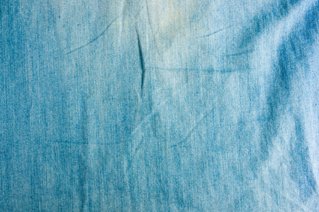Blue washed faded jeans texture with seams, clothing items, macro, close-upの写真素材