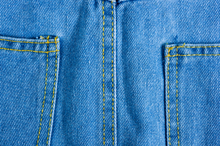 Blue washed faded jeans texture with seams, clothing items, macro, close-up