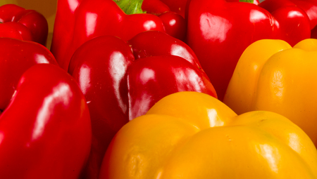 a colorful mix of the freshest red and yellow paprika, bell pepper on wooden background, close upの写真素材