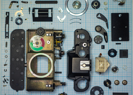 parts are completely disassembled old retro film SLR camera on graph paper, close-upの写真素材