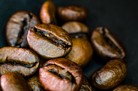 Brown roasted coffee beans on black background, close-up, macroの写真素材