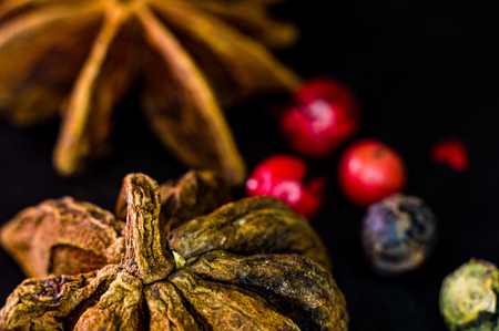 Star anise and multi-colored balls fragrant peppers on a black background, close up, macroの写真素材