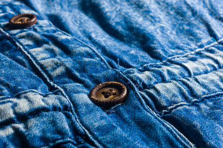 Blue washed faded jeans texture with seams, clasps, buttons and rivets, clothing items, macro, close-upの写真素材