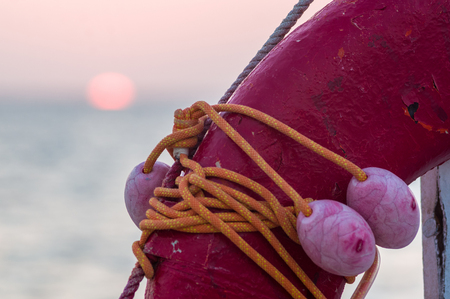 Orange emergency lifebuoy on a pebbly sea beachの写真素材