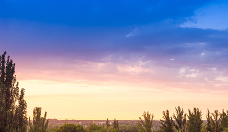 Landscape with dramatic light - beautiful golden sunset with saturated sky and clouds, peaceful nature serene background.の写真素材