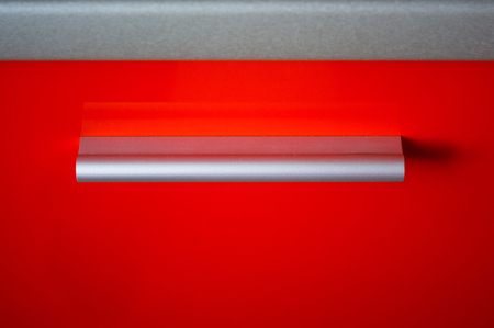 red kitchen facade with aluminum handle, close-upの写真素材