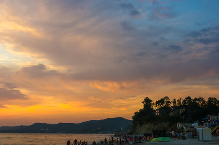 Summer sea sunset on the pebble beach, the sun, waves and clouds, beautiful dramatic lightingの写真素材