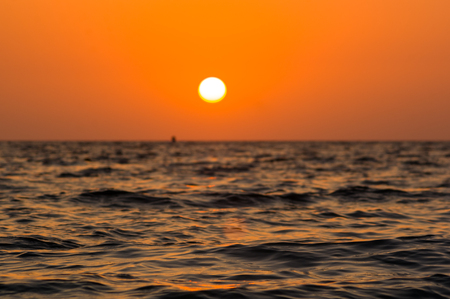 Summer sea sunset on the pebble beach, the sun, waves and clouds, beautiful dramatic lightingの写真素材