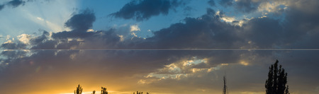 Landscape with dramatic light - beautiful golden sunset with saturated sky and clouds, peaceful nature serene background.の写真素材