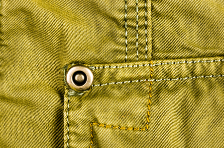 clothing items washed cotton fabric texture with seams, clasps, buttons and rivets, macro, close-up