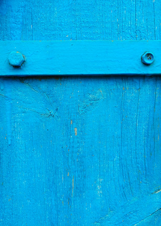 texture of old painted shabby rustic wooden fence made of planks, with rusty nails, hand-forged iron elements close-up, grunge backgroundの写真素材