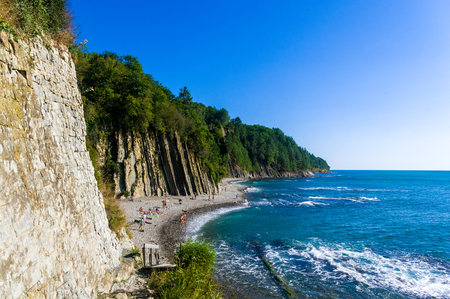 sea landscape is a pebbly beach with waves in white foam, a beautiful sky with clouds, a warm summer dayの写真素材