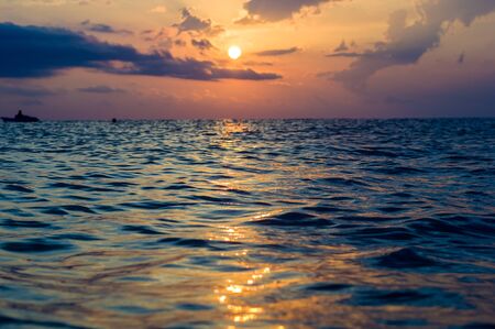 Summer sea sunset, the sun, waves and clouds, beautiful dramatic lightingの写真素材