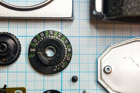 parts are completely disassembled old retro film SLR camera on graph paper, close-upの写真素材