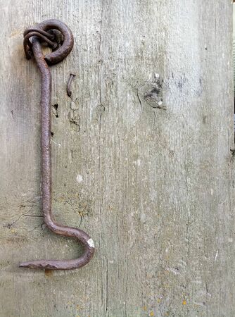 texture of old painted shabby rustic wooden fence made of planks, with rusty nails, hand-forged iron elements close-up, grunge backgroundの写真素材