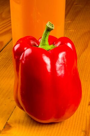 fresh red paprika, bell pepper and a bottle of pumpkin juice, close upの写真素材