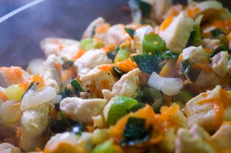 preparation of home diet dishes of white chicken meat with carrots, onions and spicesの写真素材