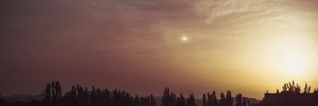 Landscape with dramatic light - beautiful golden sunset with saturated sky and clouds, peaceful nature serene background.の写真素材