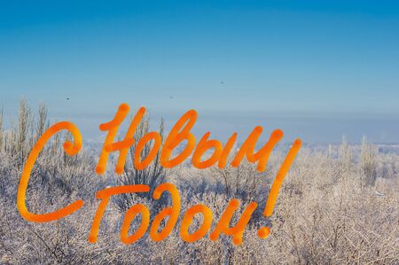 New Year Concept postcard. Winter urban landscape - snow covered trees on foggy background and congratulatory inscription, russian textの写真素材